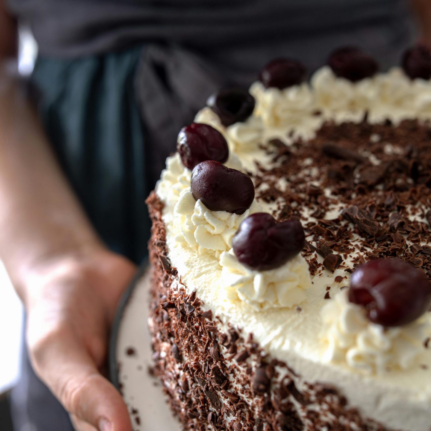 Close-up of a Black Forest cake topped with cherries and whipped cream.